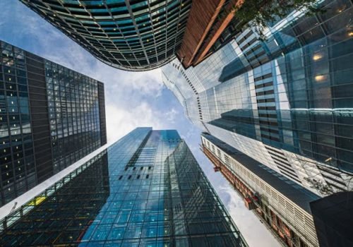 4K Footage Time lapse Low angle of tall corporate buildings skyscraper with reflection of clouds among high buildings and glass elevator in building center in London, England, United Kingdom